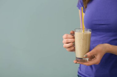 Cam fincan lezzetli smoothie gri arka plan üzerinde kadınla