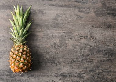 Gri ahşap arka plan üzerinde olgunlaşmış ananas