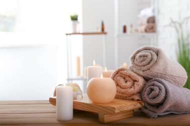 Ahşap masa üzerinde yanan mumlar ve havlu ile güzel spa kompozisyon