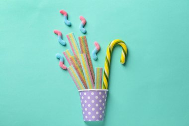 Renk arka plan üzerinde farklı lezzetli şeker ile Kupası