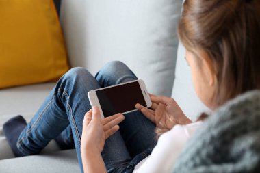 Sevimli küçük kız evde Smartphone ile oynamak