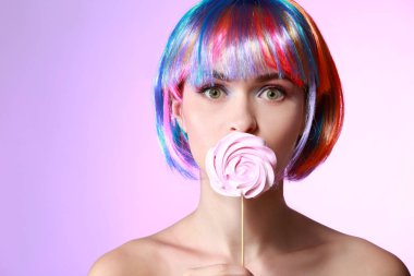 Tatlı lolipop ve peruk renk arka plan üzerinde olan güzel kadın