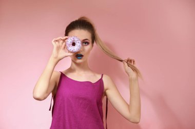 Olağandışı makyaj ve tatlı çörek renk arka plan üzerinde olan güzel kadın