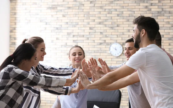 Jóvenes Poniendo Manos Juntas Oficina —  Fotos de Stock