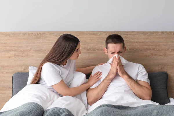インフルエンザ自宅での病気の夫の世話をする女性 — ストック写真