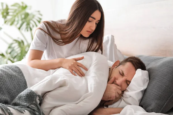 インフルエンザ自宅での病気の夫の世話をする女性 — ストック写真