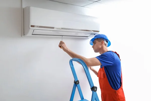 Male Technician Repairing Air Conditioner Indoors — Stock Photo, Image