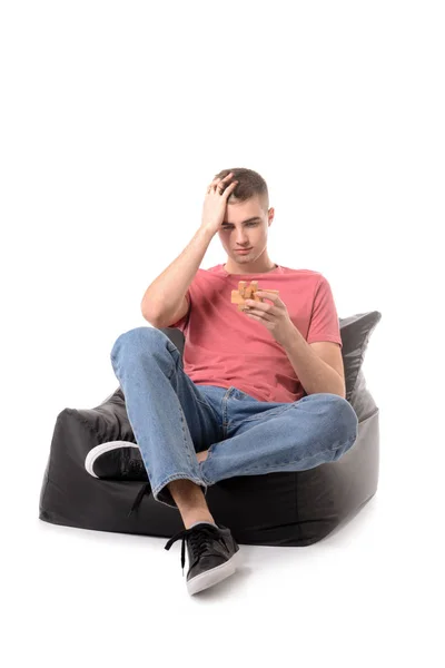 Mladý Muž Hlavolamy Sedí Bezrámové Křeslo Proti Bílým Pozadím — Stock fotografie