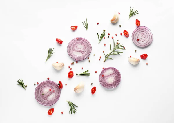 Cut onion and spices on white background, flat lay