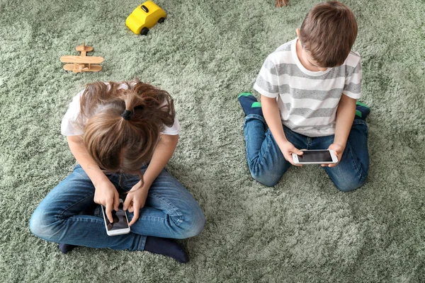 Schattige Kleine Kinderen Spelen Met Smartphones Thuis — Stockfoto