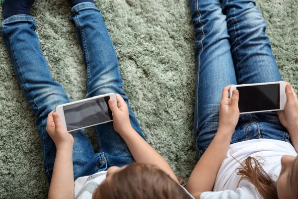 Schattige Kleine Kinderen Spelen Met Smartphones Thuis — Stockfoto