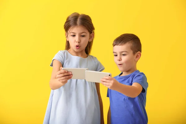 Schattige Kleine Kinderen Spelen Met Smartphones Kleur Achtergrond — Stockfoto