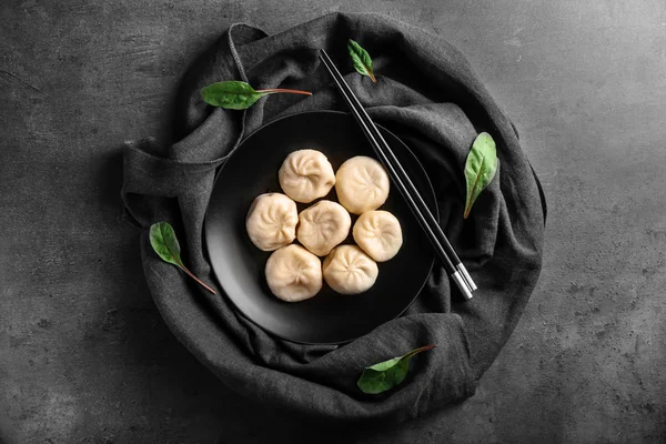 Plate with tasty Chinese dumplings on table