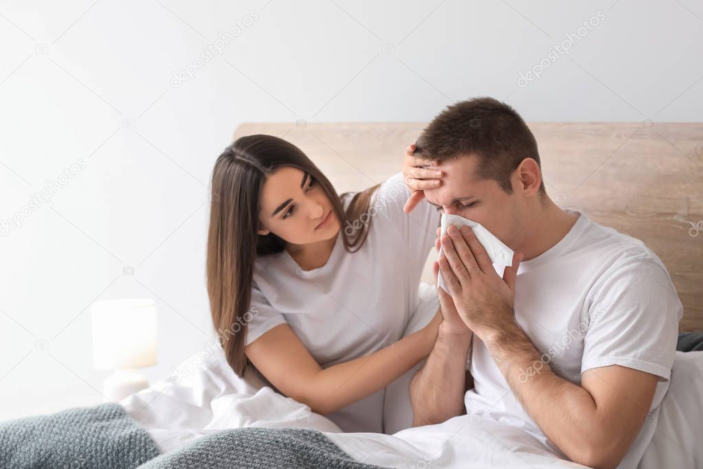 Woman taking care of her husband ill with flu at home