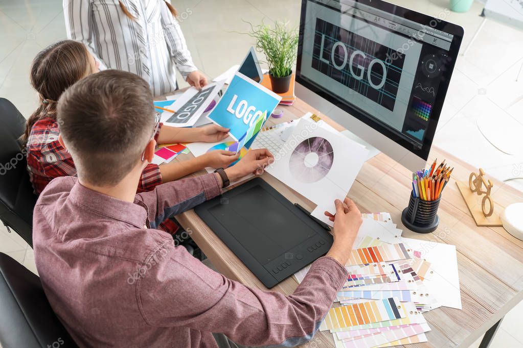 Male designer with colleagues working in studio