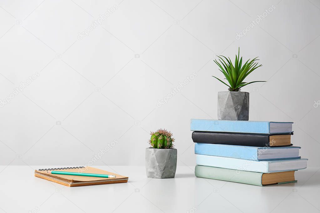 Green plants in pots with stationery on light table