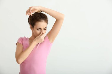 Güzel ve genç birbayan duygu ışık arka plan üzerinde ter kokusu. Deodorant kullanmanın kavramı
