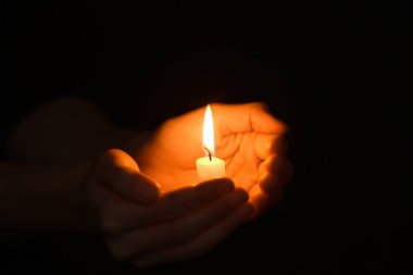 Karanlıkta mum yanan ile eller