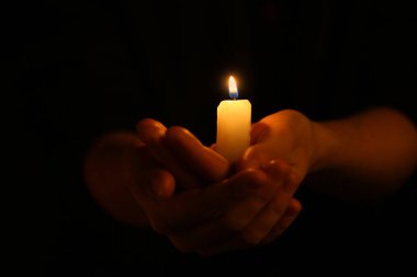 Karanlıkta mum yanan ile eller