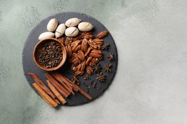 Kayrak plaka ile pekan fındık ve baharat ışık arka plan üzerinde