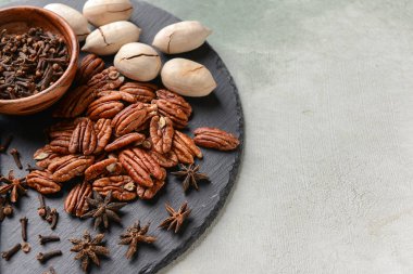 Kayrak plaka ile pekan fındık ve baharat ışık arka plan üzerinde