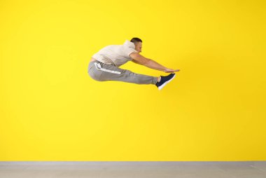 Genç erkek dansçı renk duvara yakın atlama