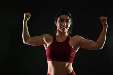 Sportif kaslı kadın koyu arka plan üzerinde