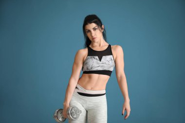 Renk arka plan üzerinde halter ile sportif kaslı kadın