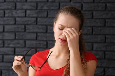 Karanlık tuğla zemin üzerine kötü görme ile kadın portresi