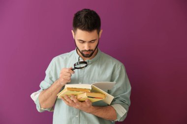 Genç adam kötü görme renk arka plan üzerinde kitap okuma ile