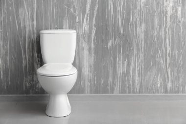 Modern seramik klozet tuvalet içinde gri duvarının yakınında