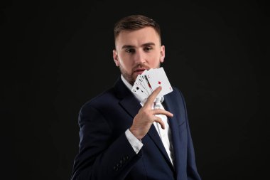 Koyu arka plan üzerinde kartlarla yakışıklı adam