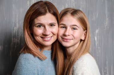 Mutlu anne ve kızı gri arka plan üzerinde portresi