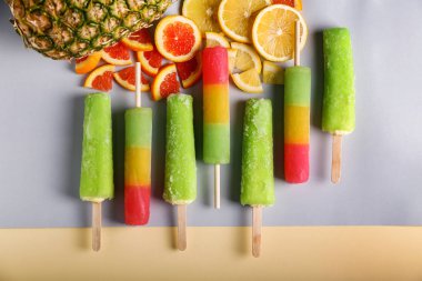 Renk arka plan üzerinde lezzetli çubuklu dondurmayı ile kompozisyon