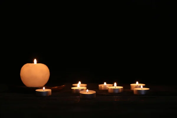 在黑暗中在木制上燃烧的美丽的蜡烛 — 图库照片