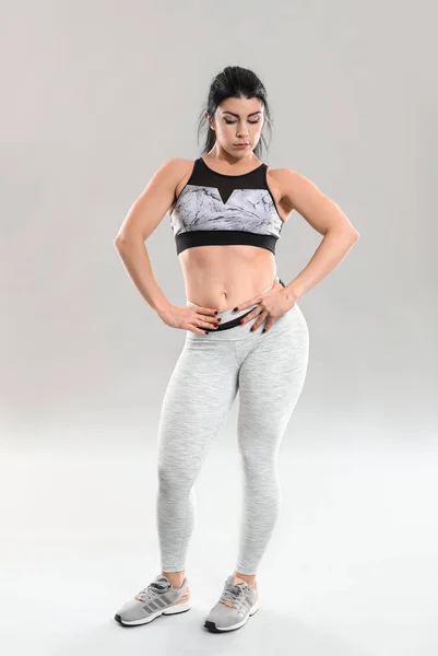 Sporty muscular woman on grey background