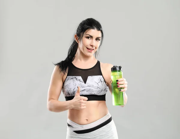 Sportig Muskulös Kvinna Med Flaska Vatten Grå Bakgrund — Stockfoto