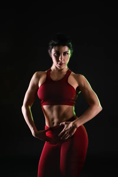 Sporty muscular woman on dark background