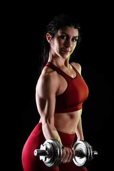 暗い背景上のダンベルのスポーティな筋肉女 — ストック写真