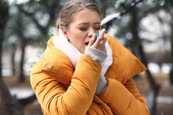 有吸入器的年轻妇女有哮喘发作在室外 — 图库照片