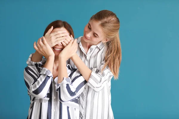 Happy Daughter Covering Eyes Her Mother Color Background — Stock Photo, Image