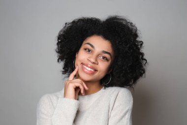 Gri arka plan üzerinde genç Afrikalı-Amerikalı kadın portresi
