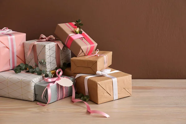 Festliche Geschenkboxen Auf Dem Tisch Vor Farbigem Hintergrund — Stockfoto