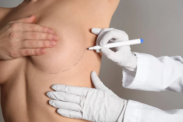 Doktor Kadın Meme Gri Arka Plan Karşı Kozmetik Cerrahi Operasyondan — Stok fotoğraf