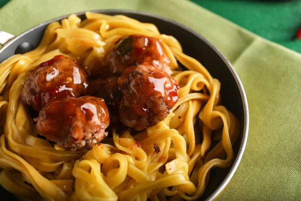 Tasty pasta with meat balls in pan on table, closeup