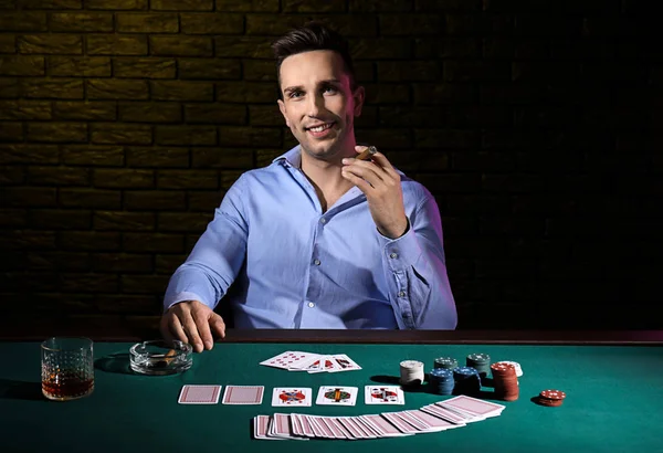 Handsome male player at table in casino