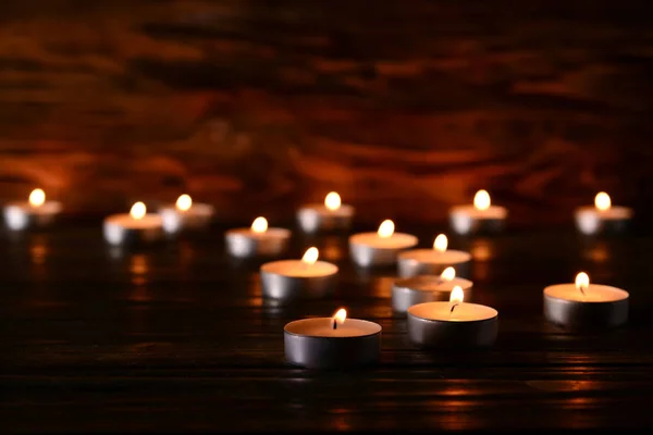 许多人在黑暗中燃烧着桌子上的蜡烛 — 图库照片
