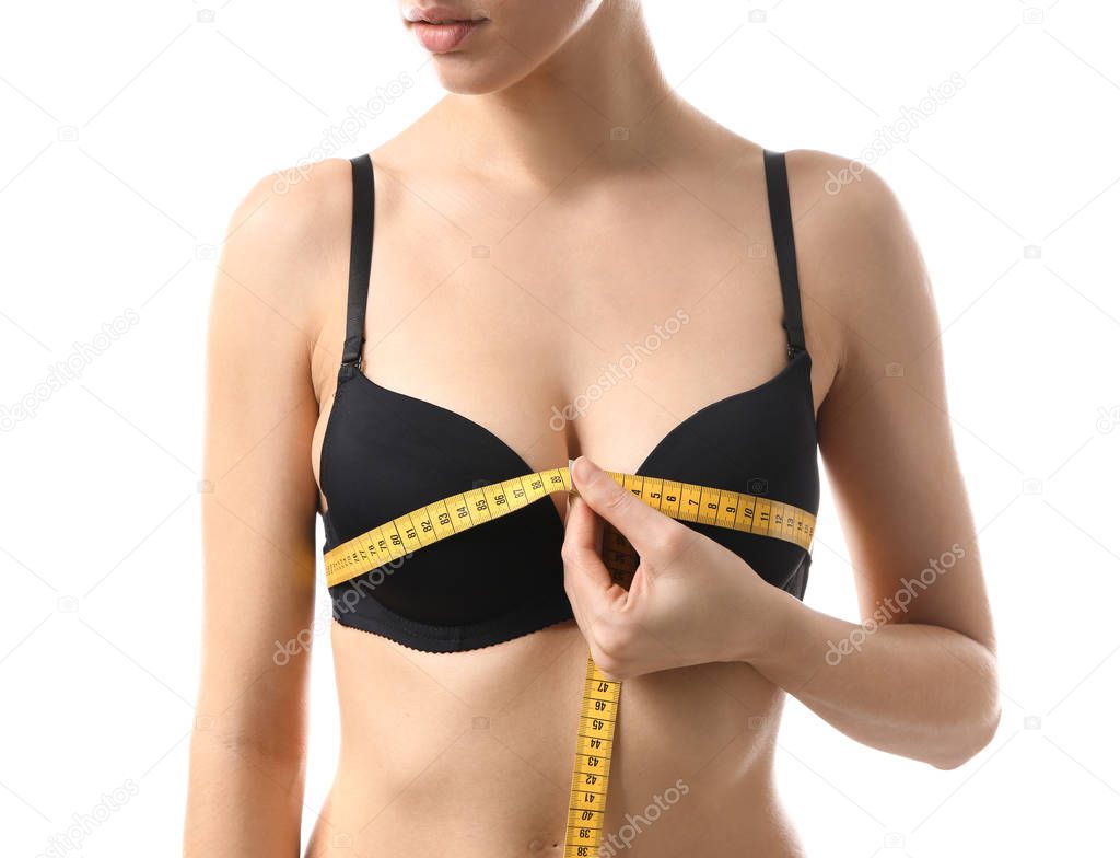 Young woman measuring her breast on white background