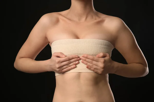 Kvinna Med Bandage Hennes Bröst Mot Mörk Bakgrund Breast Augmentation — Stockfoto