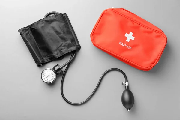 灰色の背景に血圧計と応急キットです 医療コンセプト — ストック写真